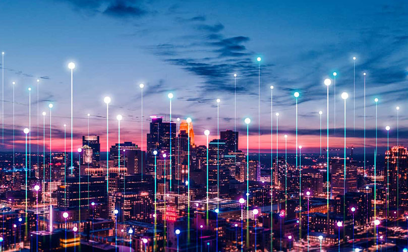 Vue d'une ville pleine de bâtiments, la nuit, avec des icônes et des illustrations qui en sortent