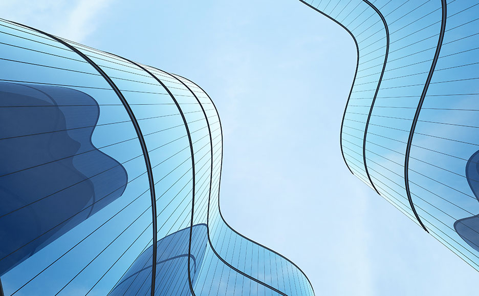 Two curved blue glass buildings against a clear blue sky, showcasing futuristic architectural design.