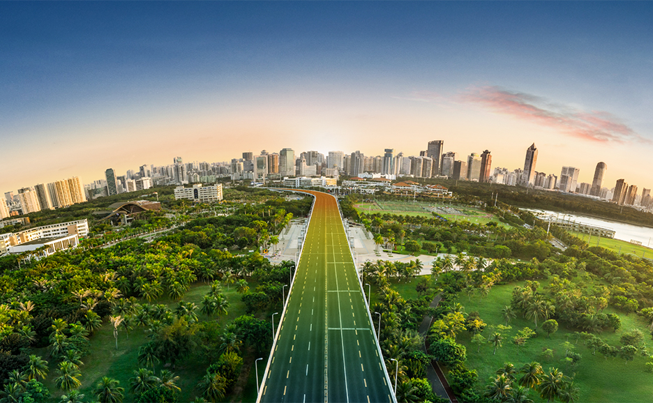 緑豊かな公園を抜け、街の端まで道が続く近未来的な風景