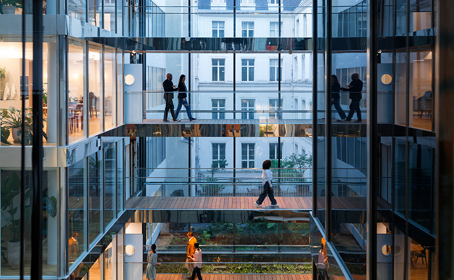 Interior view of a modern office building with people walking on different levels.