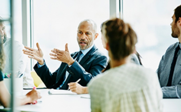 A Western man explaining with hand gestures in a meeting